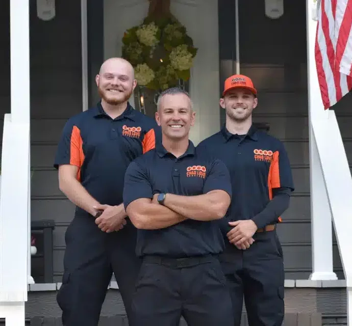 Chad Love Services Technicians standing in front of a Charlotte home smiling