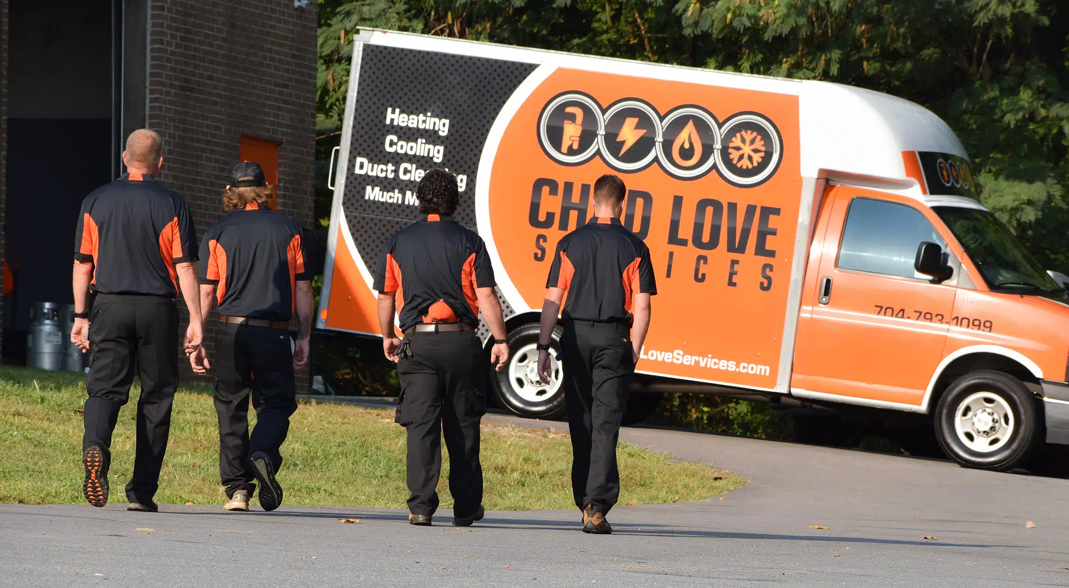 Chad Love services team walking to wrapped Chad Love truck in Concord, NC.