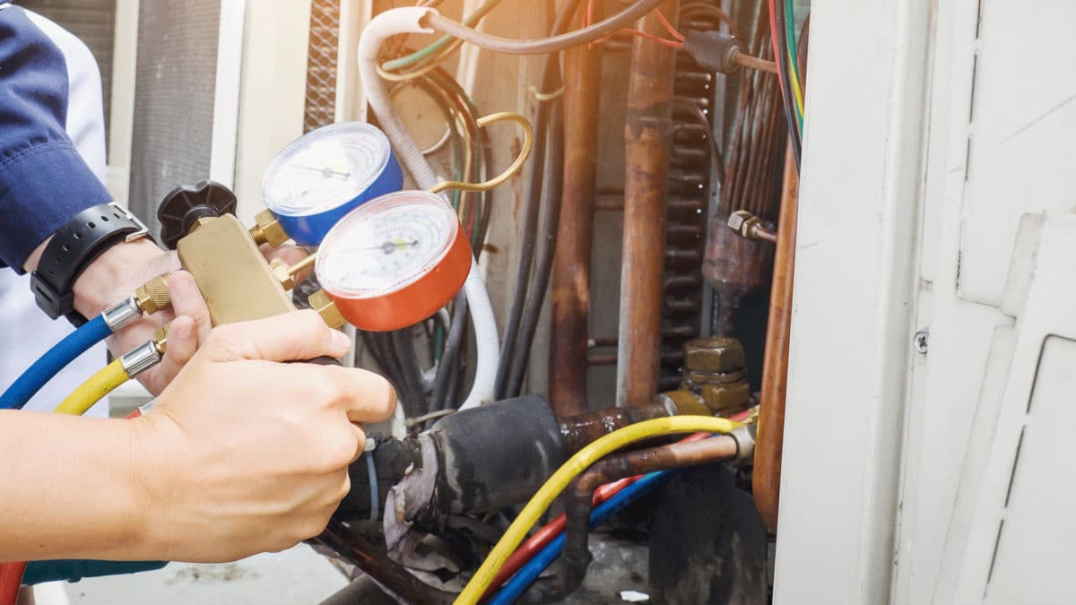 AC repairman working on AC unit