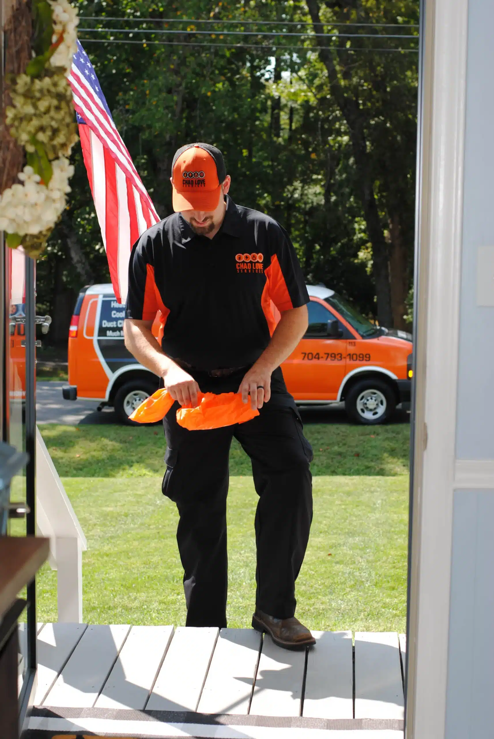 Chad Love Services electrician putting on protective footwear be fore entering a Davidson, NC home