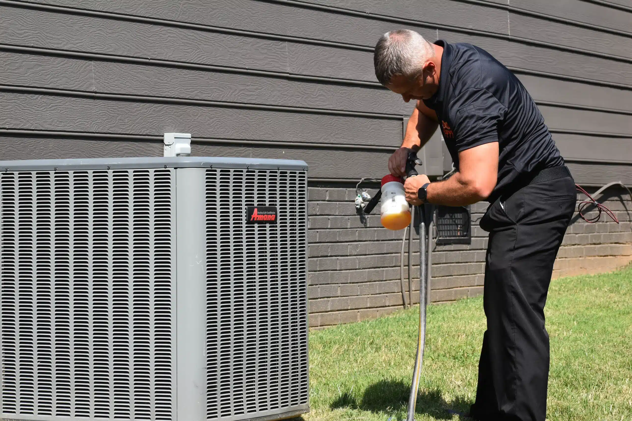 Chad Love Services technician repairing AC unit outside of a residential home in Cornelius, NC