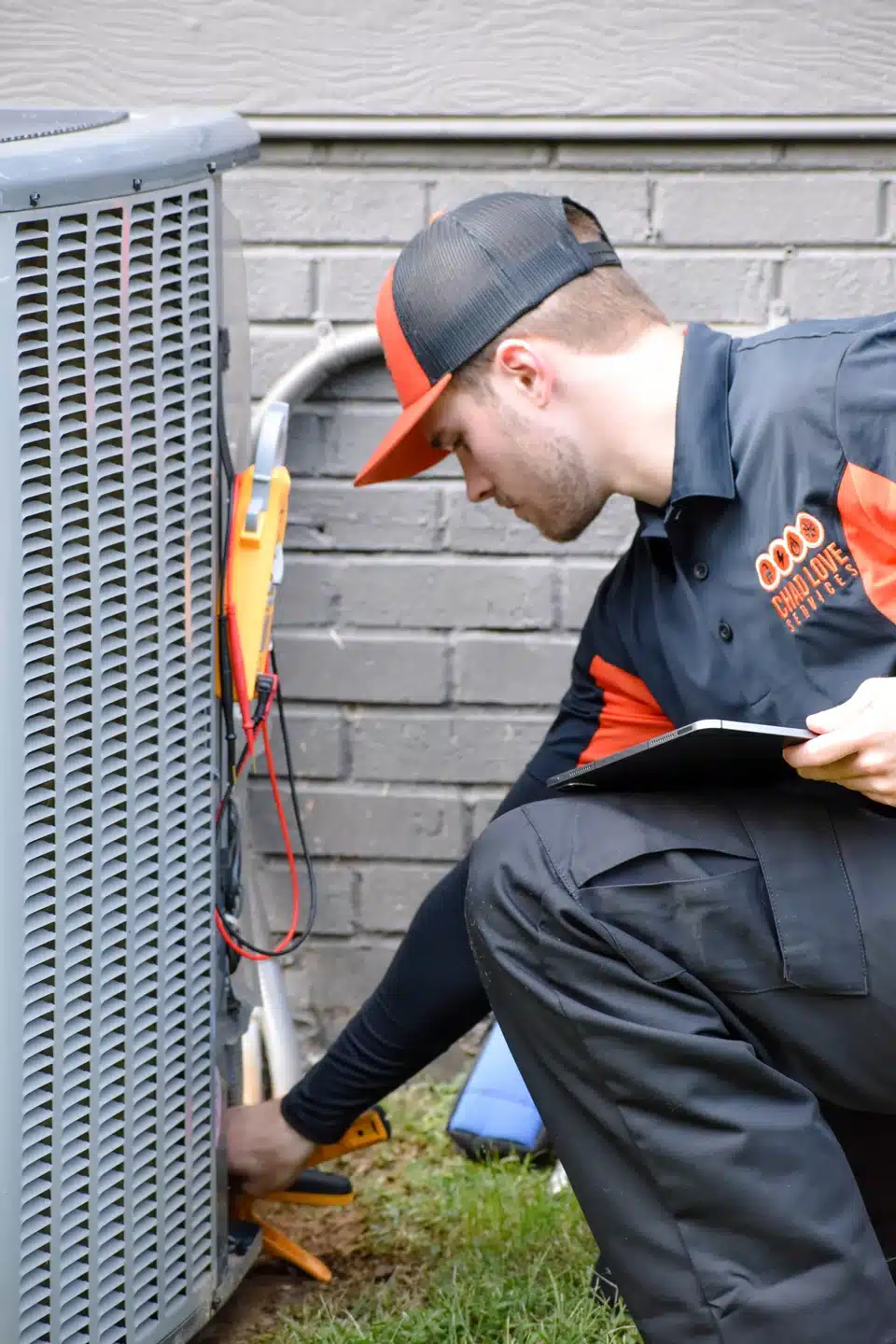 HVAC technician performing AC tune up outside of a house in Charlotte