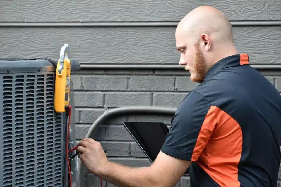 HVAc technician performing AC tune up outside of a house in Davidson, NC