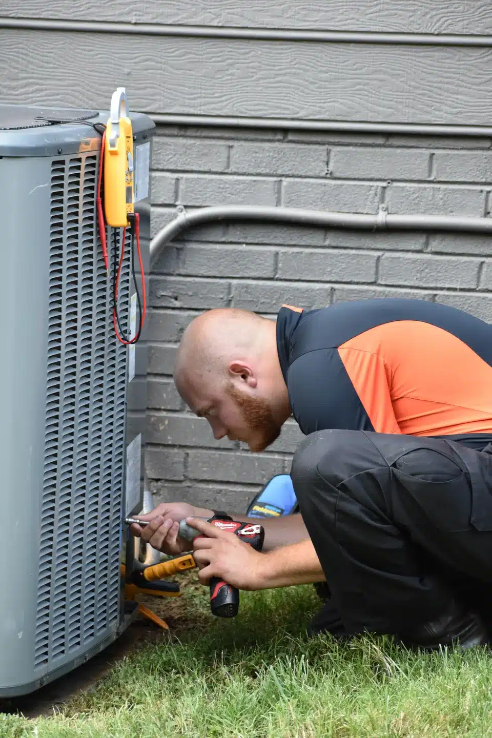 HVAC technician performing AC maintenance outside of a home in Charlotte