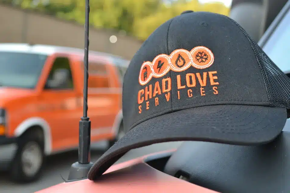 Chad Love Services baseball cap sitting atop a van in Cornelius, NC