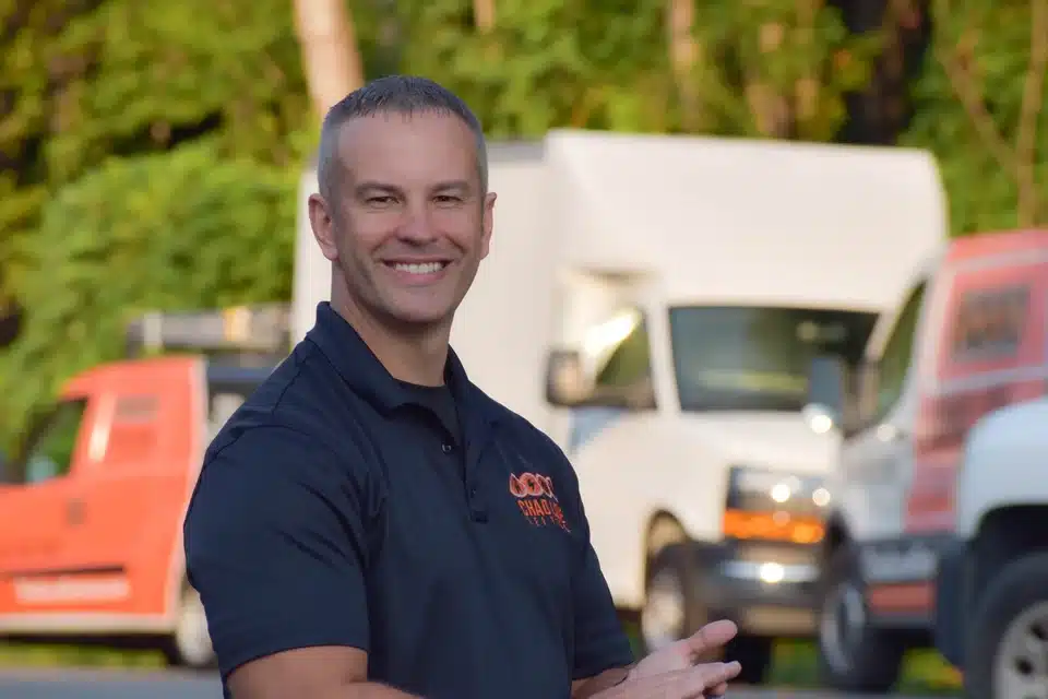 Chad Love smiling in front of trucks in Davidson, NC