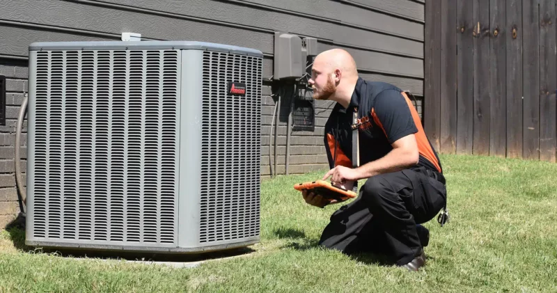 Chad Love services tech looking at AC outside of residential home in Concord, NC.