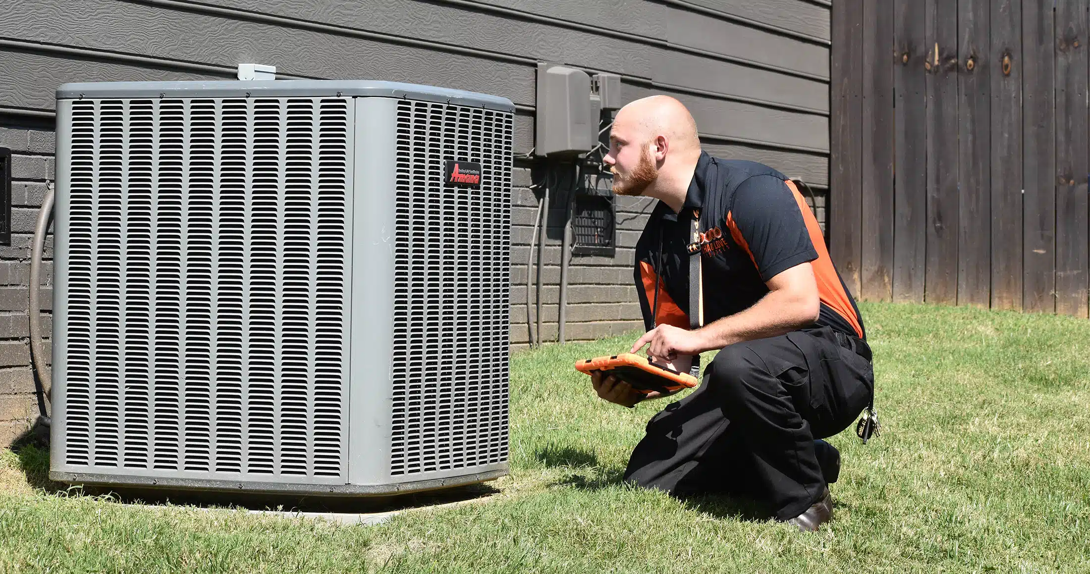 Chad Love services tech looking at AC outside of residential home in Concord, NC.